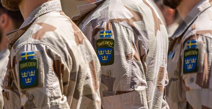 Närbild på svenska soldater i den uniform som används vid intrenationella insatser. 