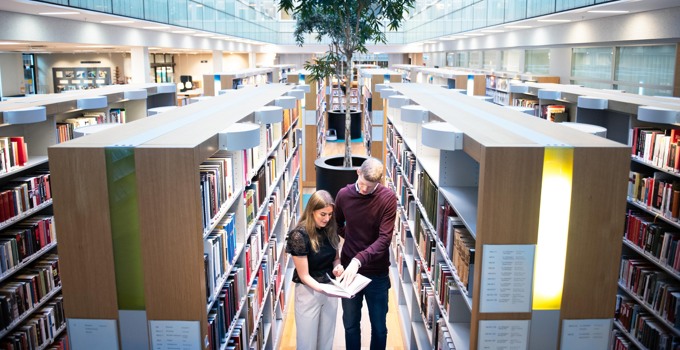 Två studenter i ett bibliotek