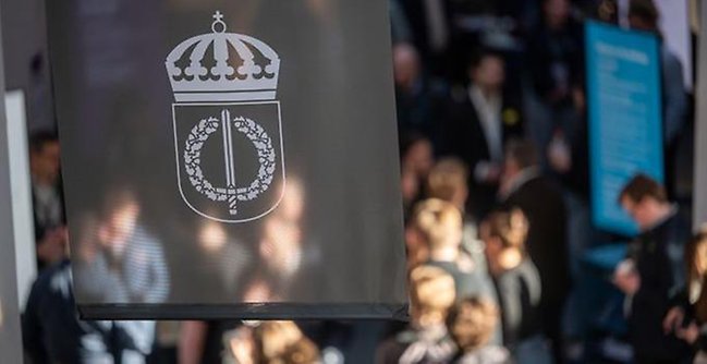 FHS flagga och studenter i bakgrunden